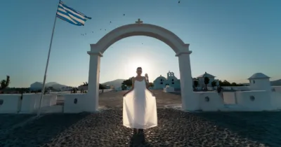 Γυναίκα με λευκό φόρεμα κάτω από αψίδα εκκλησίας