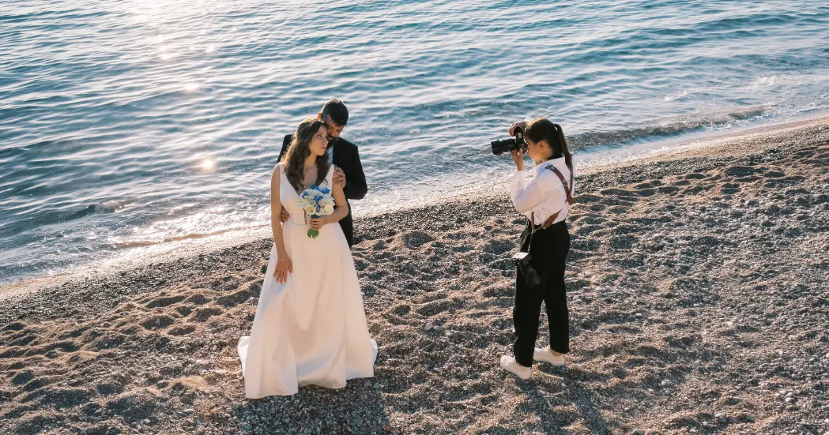 Νύφη και γαμπρός φωτογραφίζονται σε παραλία